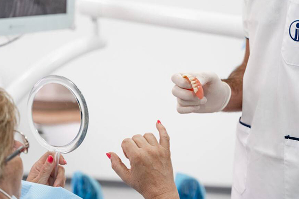 Clínica Médica Jardim - Prótese Fixa - Paciente a Observar a sua Prótese - Causas, Consequências e Soluções mais comuns para a Perda Dentária