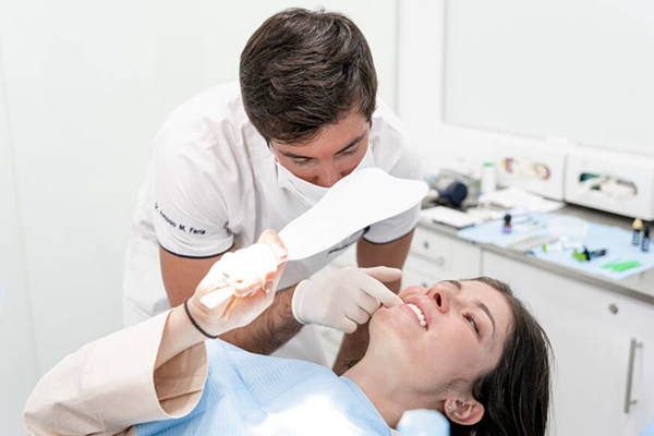 Clínica Médica Jardim - Paciente a verificar sorriso ao espelho com o Dentista